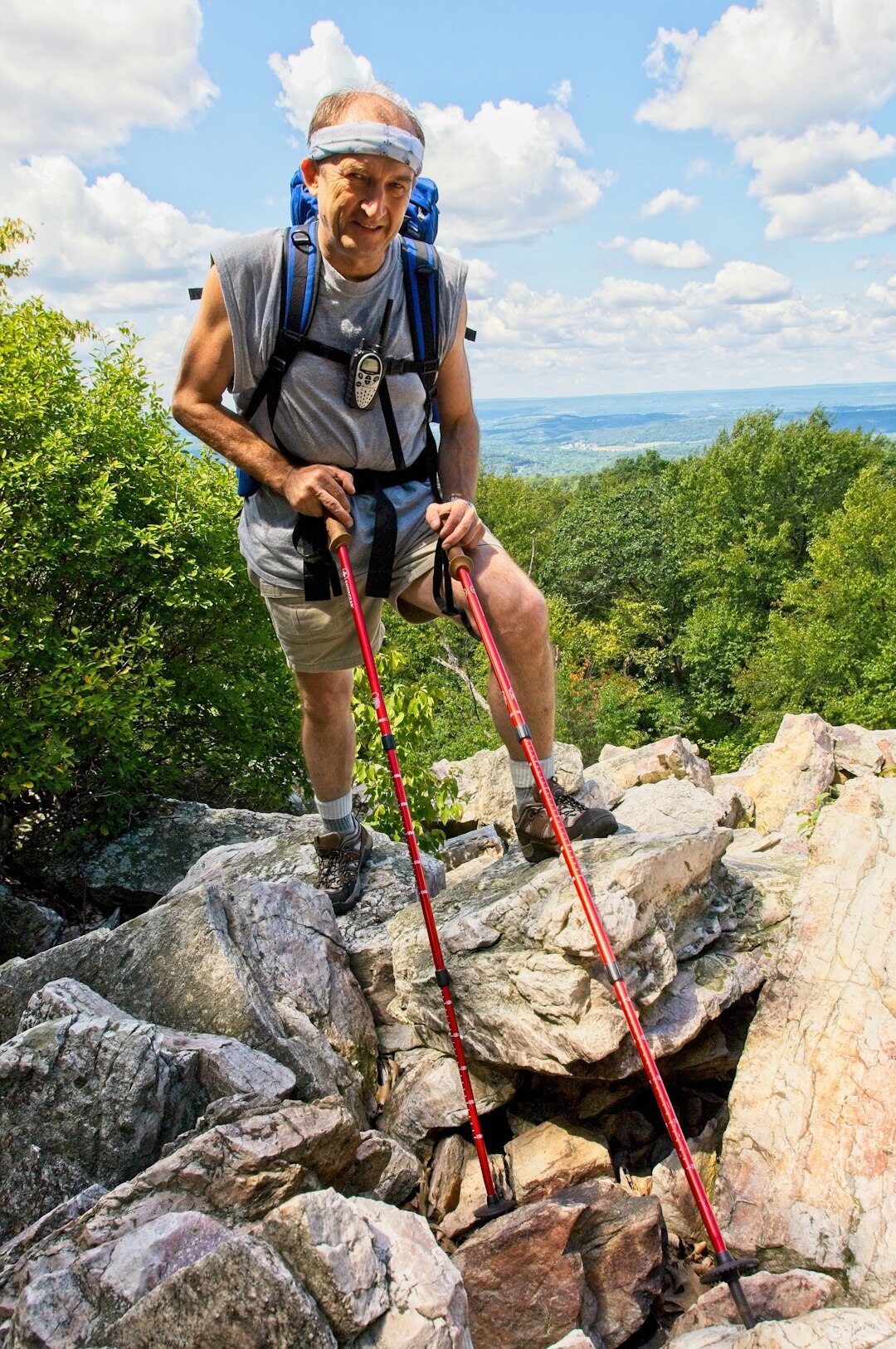 Senior woman hiking outdoors with a walking pole
