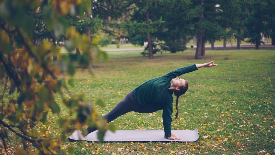 Senior woman practicing yoga outdoors in a park